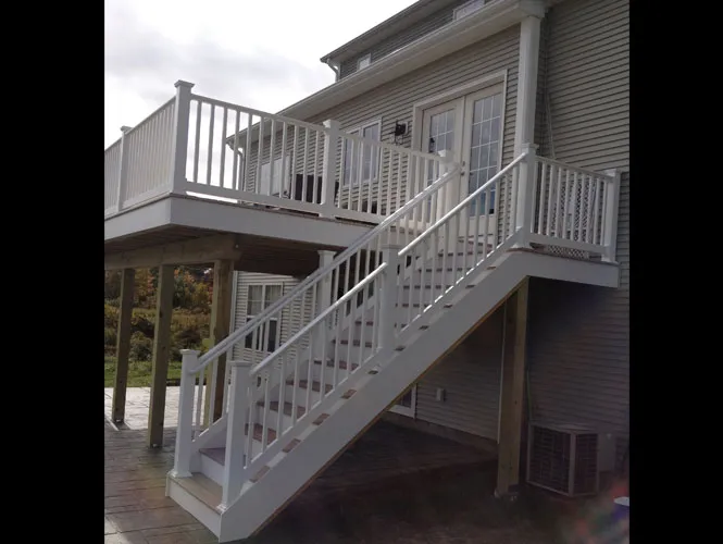 Raised deck with painted railings and a long run of exterior stairs